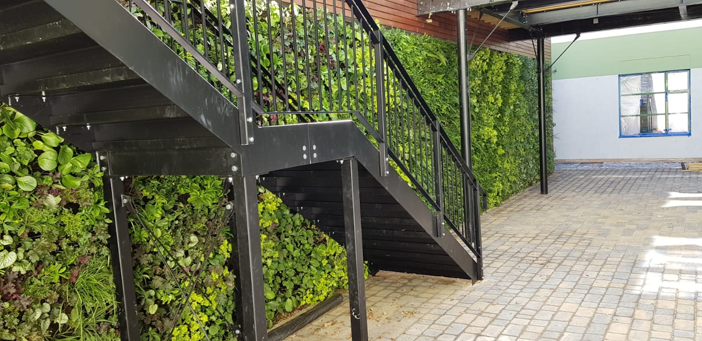 Living Wall Stretching Length Of A Communal Courtyard With Staircase