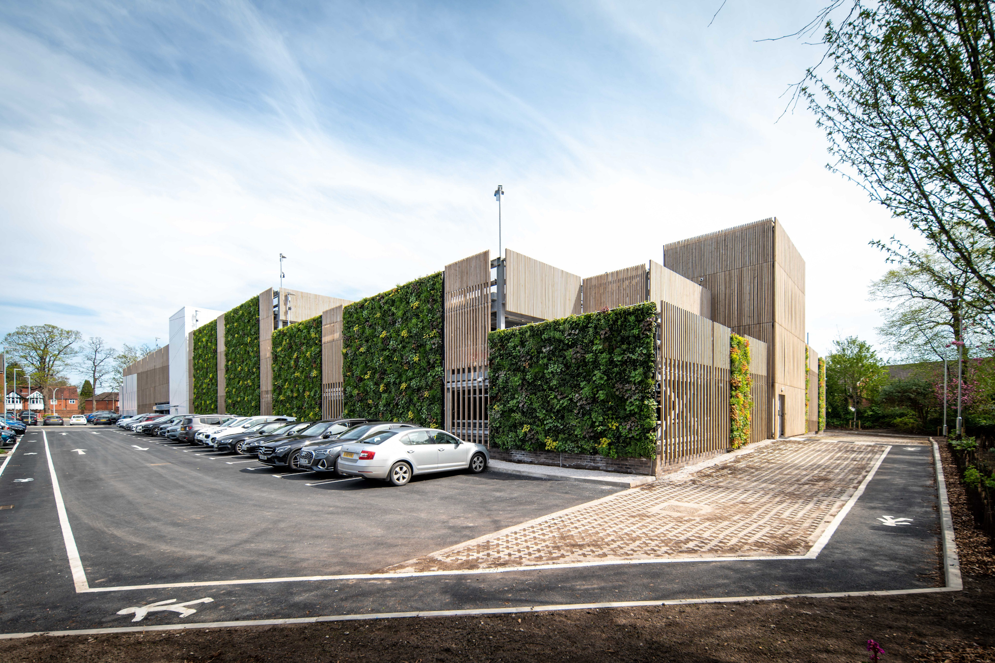 tiered car park with a timber facade and green walls and cars