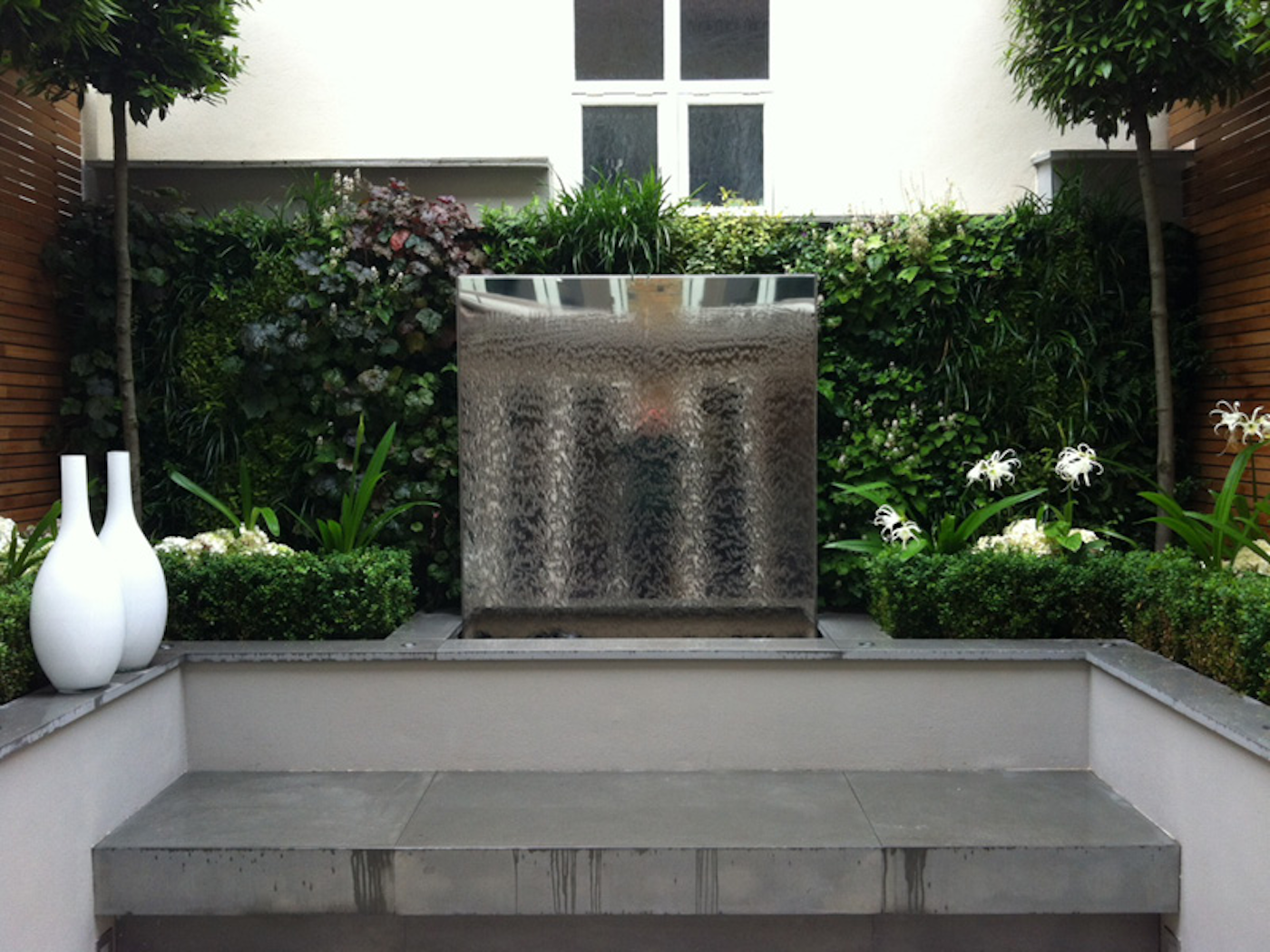 livng wall surrounding a water feature and other aesthetic garden features