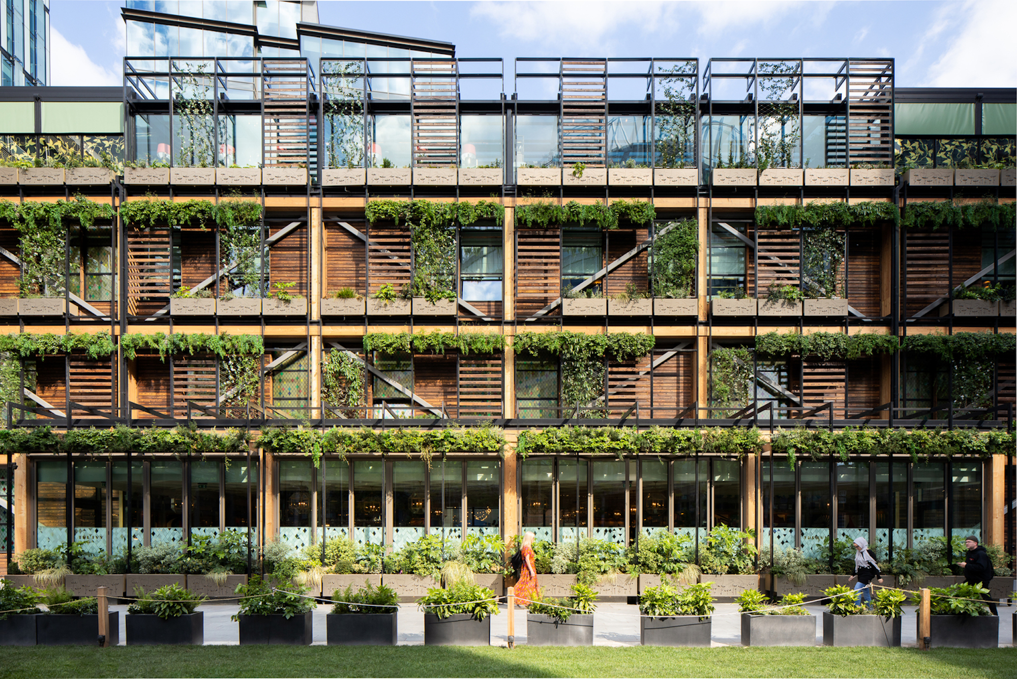 eine Gebäudefassade mit Holz und Pflanzen