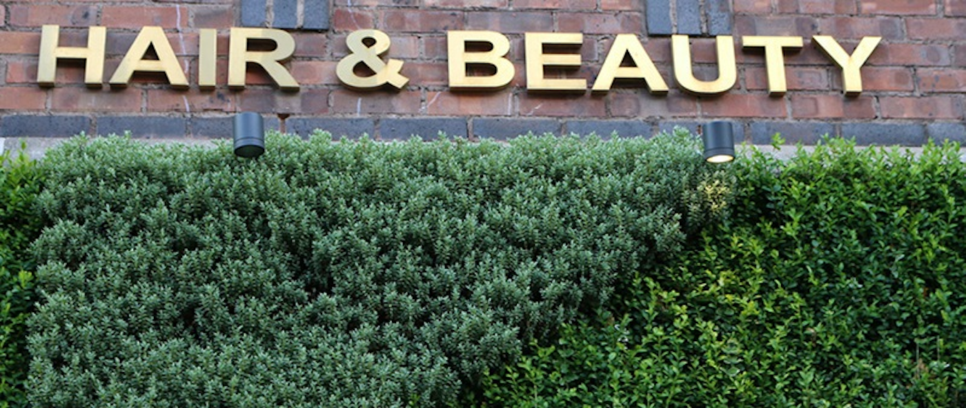 signage for beauty salon and living wall below