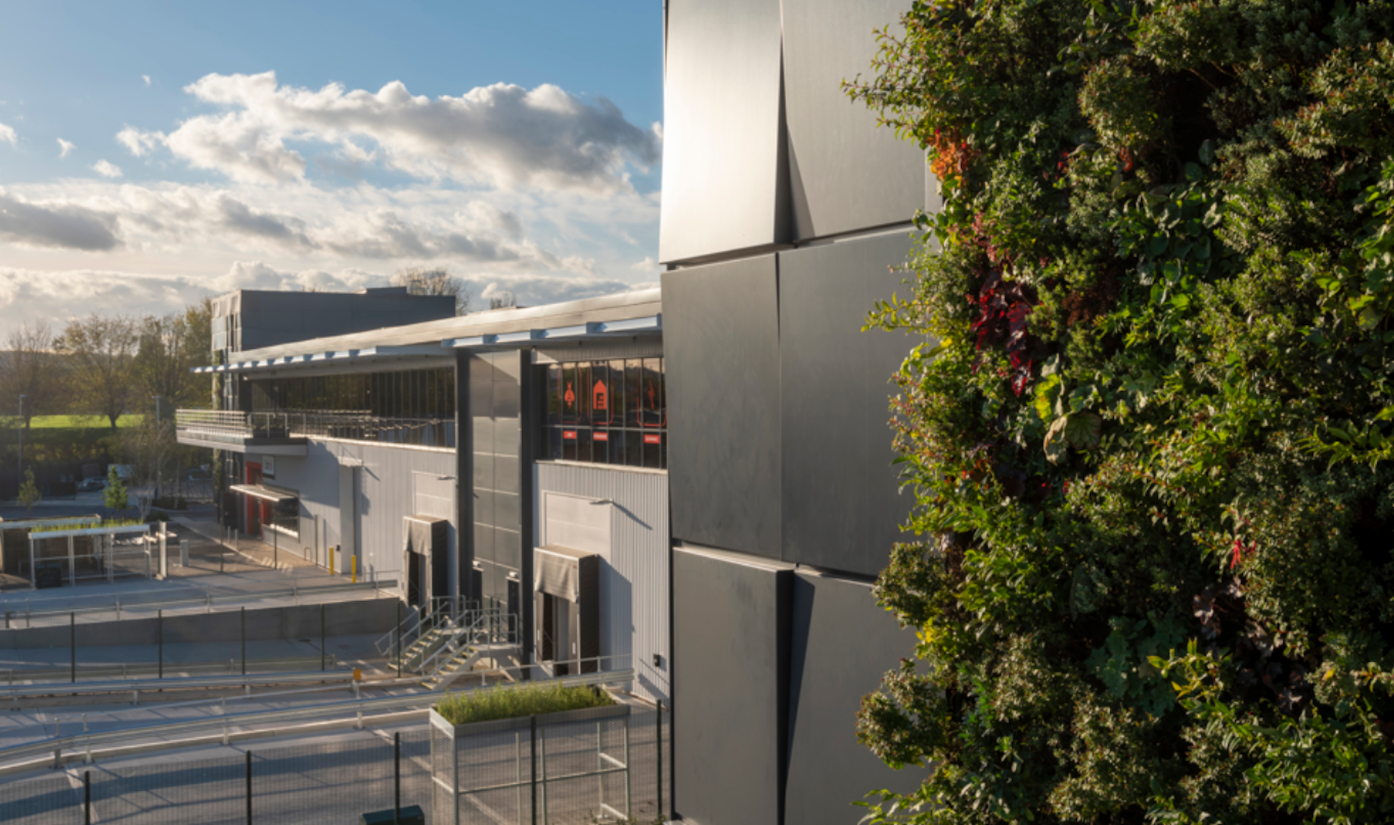 a living wall in the foreground in an industrial estate