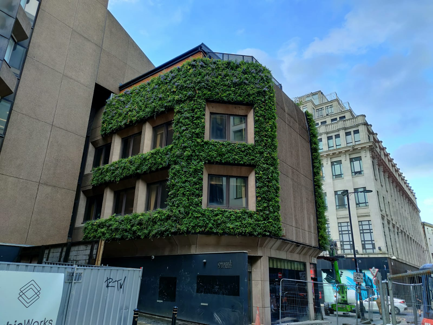green wall on side of 1960s style building around windows