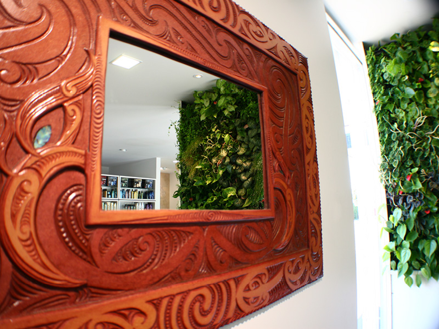 living wall of interior plants in the reflection of an ornate mirror in a hair salon