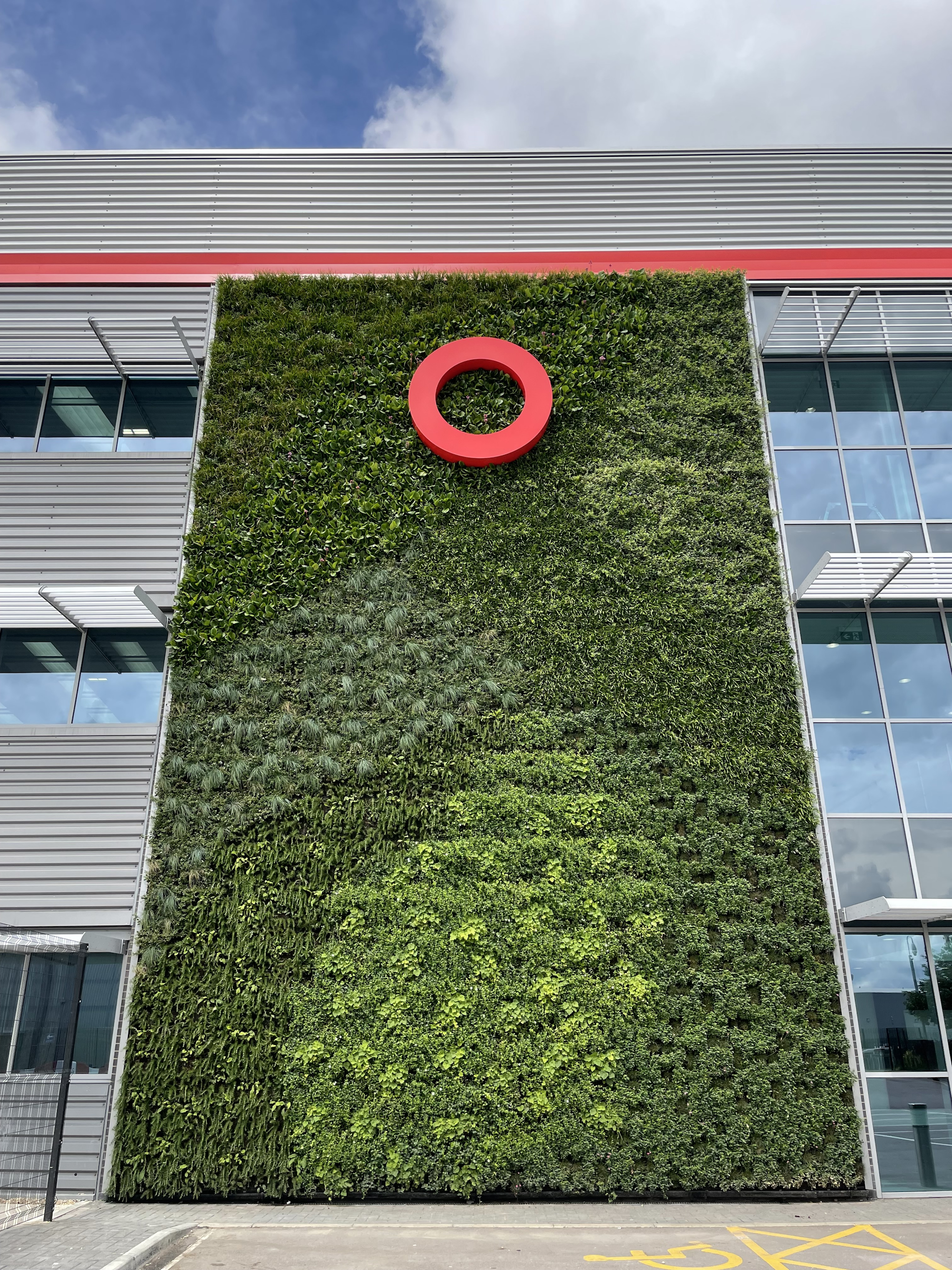 evergreen living wall on commercial building with red signage