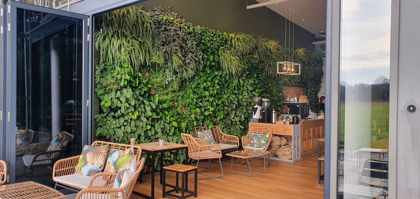 Lebende Wand als Kulisse für ein nachhaltiges Café in einem Pavillongebäude