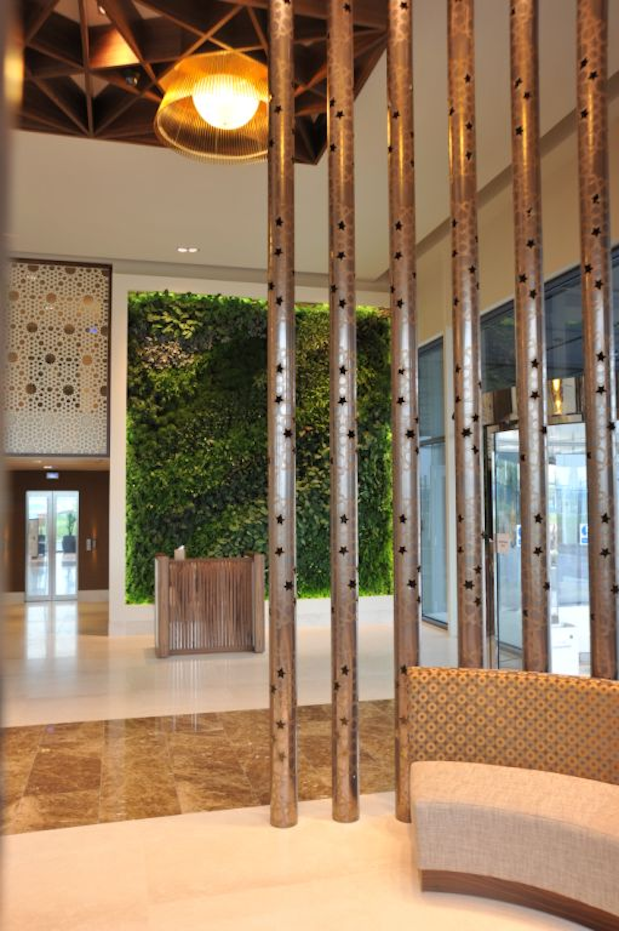 luxurious airport lounge with a living natural vertical garden in the background behind the reception desk