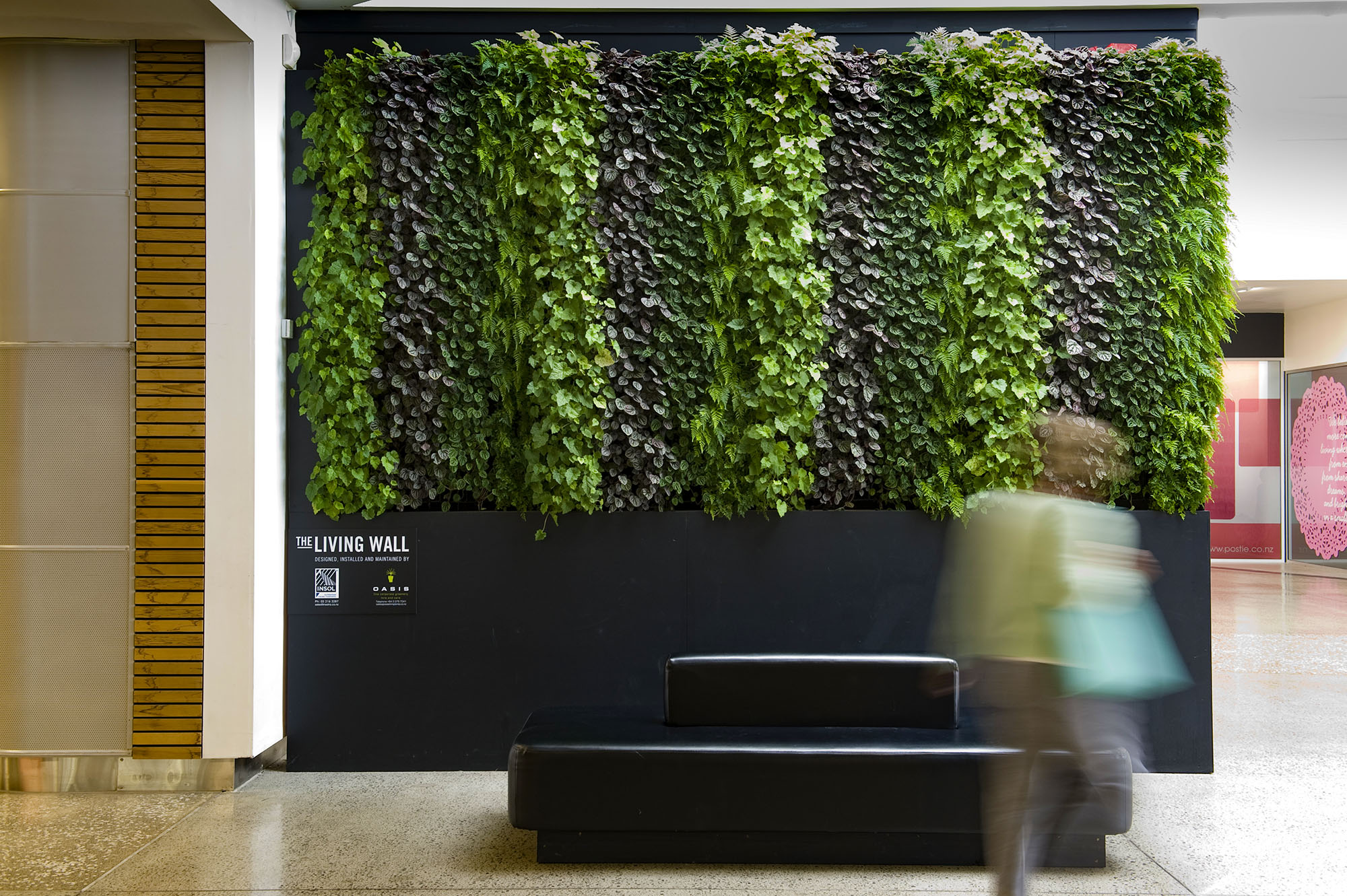 striped natural living wall behind seating in a mall