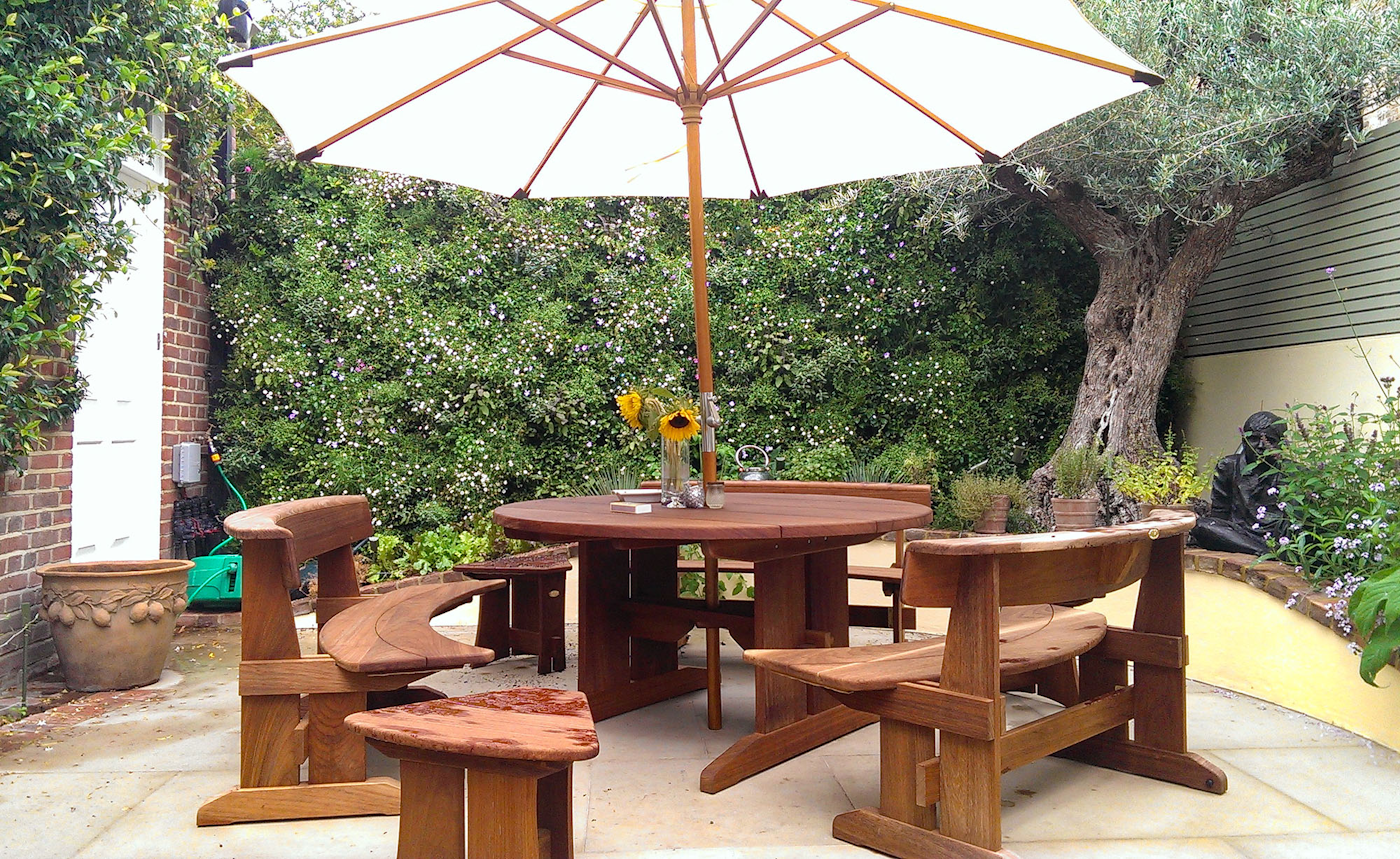 garden table and chairs with parosol and living wall